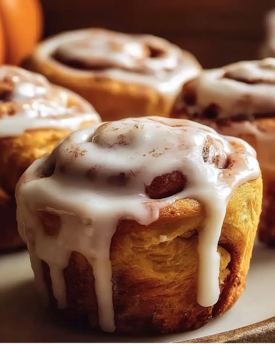 Pumpkin Cinnamon Roll Muffins 1 Freshly baked pumpkin cinnamon roll muffins with cream cheese glaze