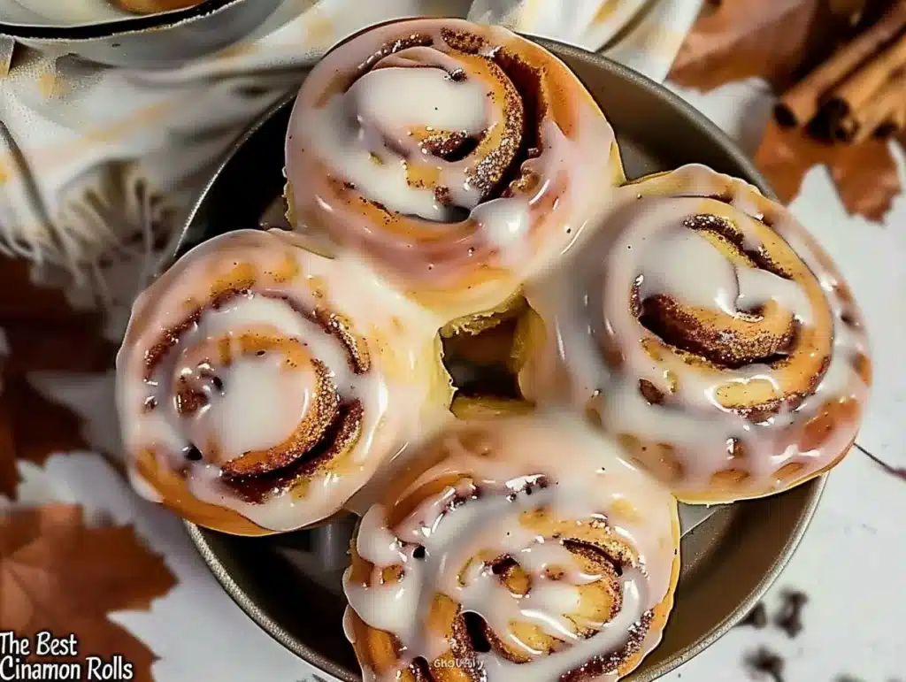 Freshly baked cinnamon rolls with creamy frosting on a plate