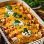 A plate of ultimate quick and easy chicken enchiladas topped with cheese and herbs