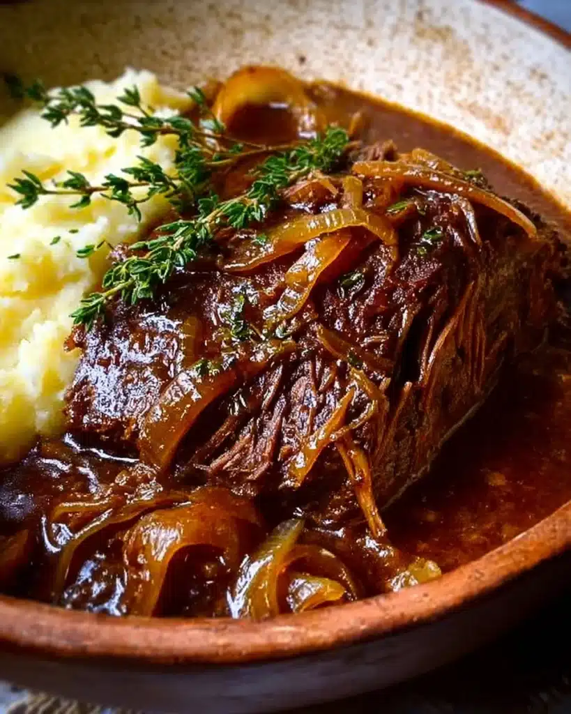 Delicious French Onion Pot Roast served with caramelized onions and herbs.